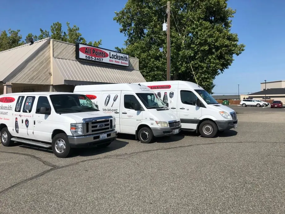 Three white All Points Locksmith vans parked in front of the shop, the All Points sign and 585-2407 on the building